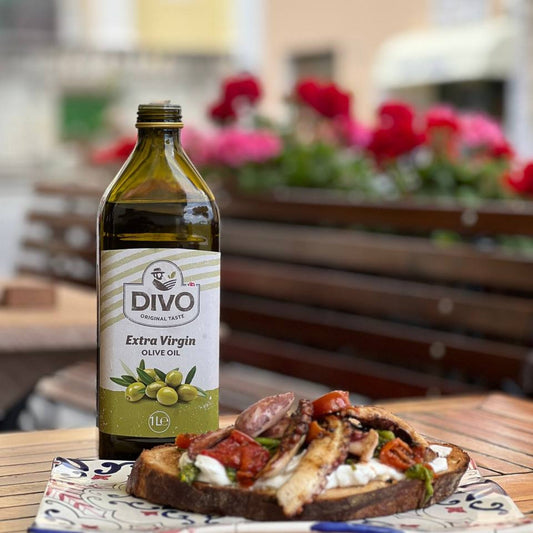 DIVO Natives Olivenöl Extra mit Bruschetta auf rustikalem Holztisch — mediterrane Tradition aus Kampanien